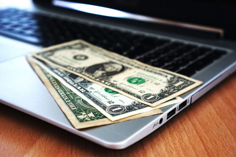 Banknote resting on a laptop representing online pricing