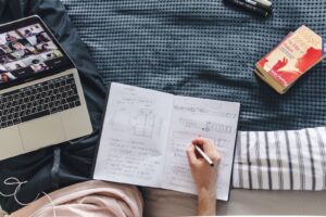 Laptop, notebook and book laid out for study
