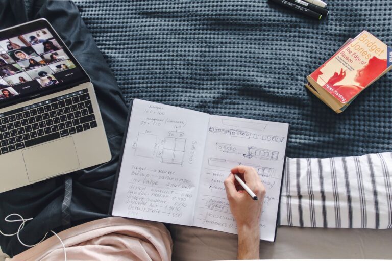 Laptop, notebook and book laid out for study