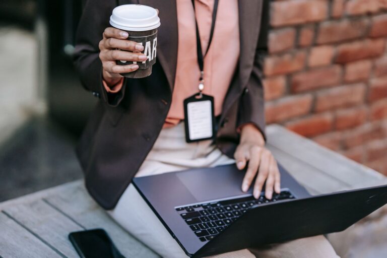 Entrepreneur with a laptop and coffee on a bench