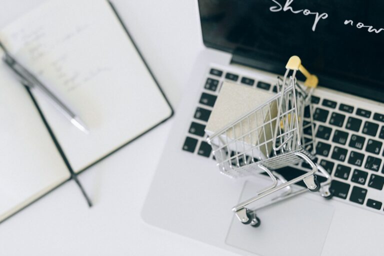 Miniature shopping trolley on a laptop keyboard