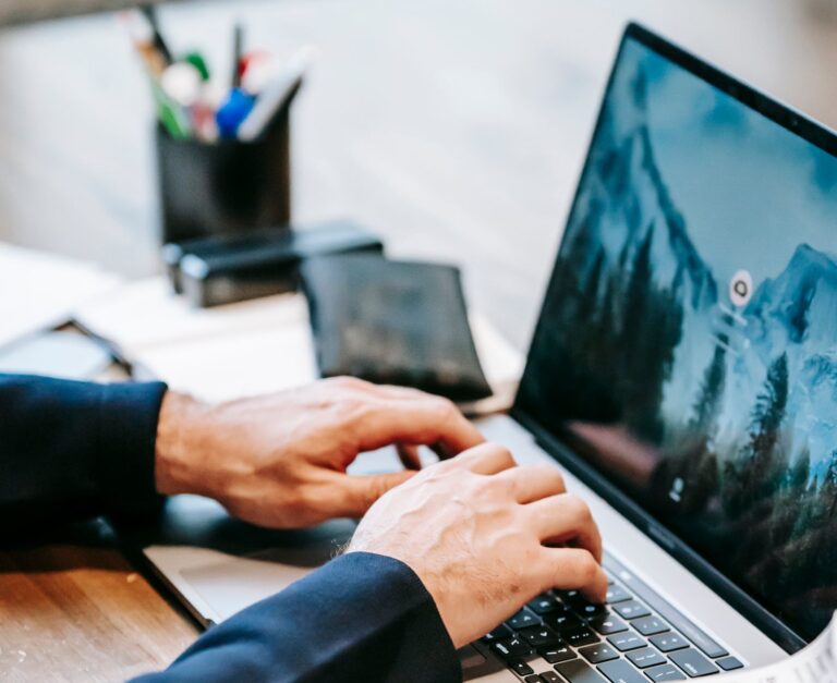 Professional working at a laptop with papers and a phone