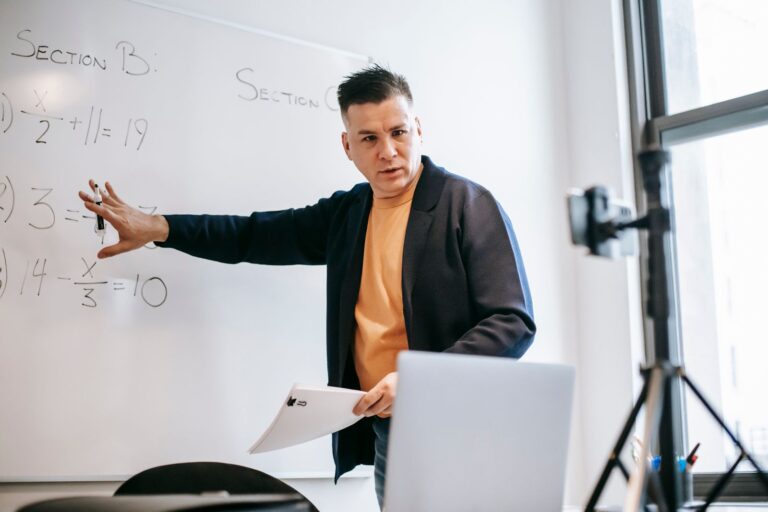 Instructor presenting online with a laptop and whiteboard