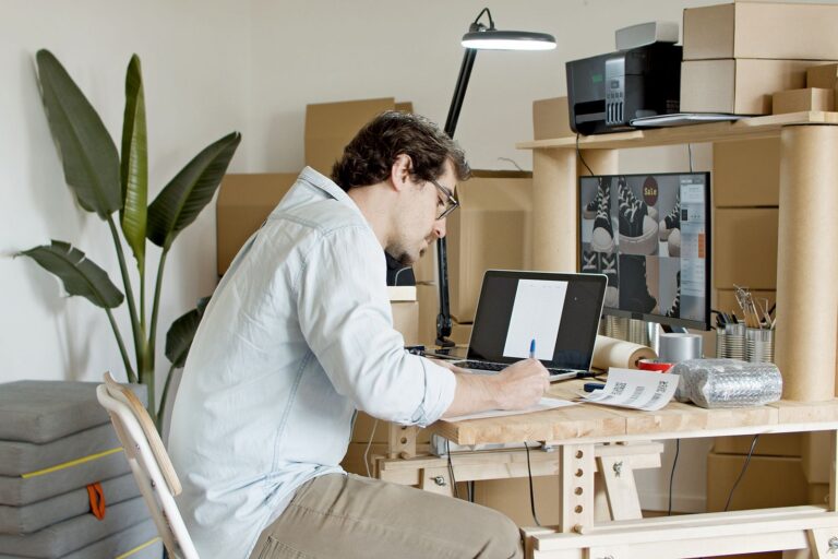 Business owner packing orders beside a laptop